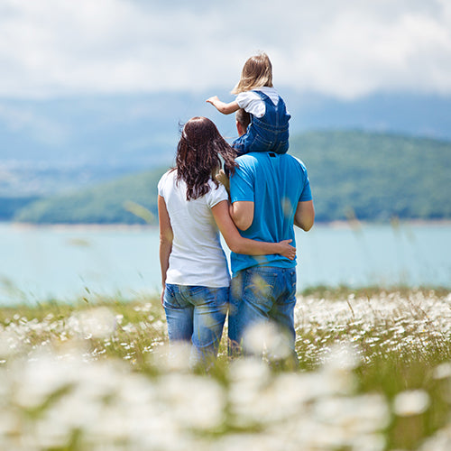 Mother and father walking with child on shoulders